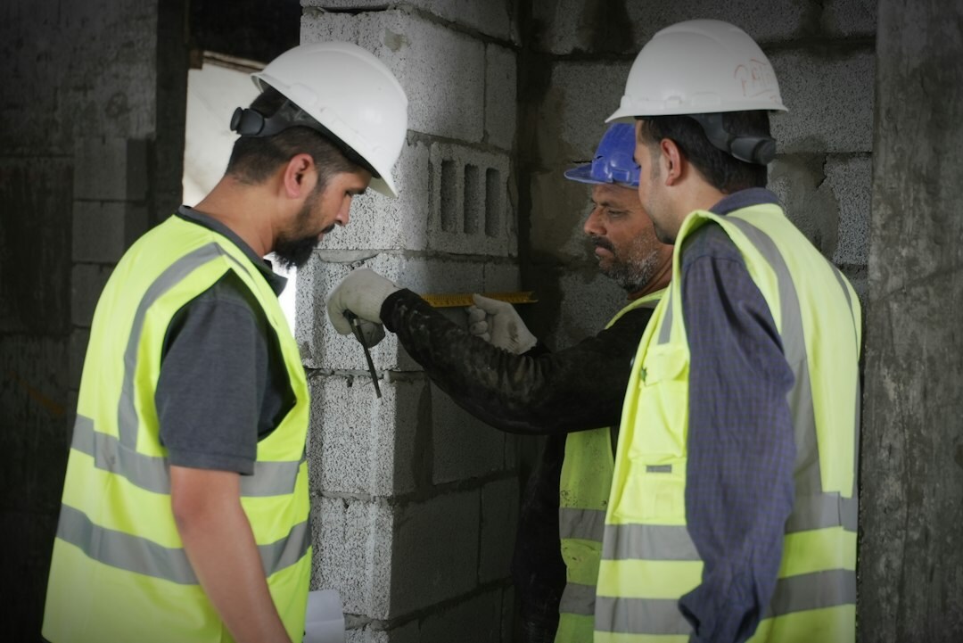 Construction workers in high-visibility clothing inspecting a building renovation site